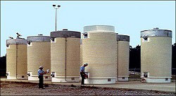 image of Storage and Transportation of Spent Nuclear Fuel with two workers inspecting of an array of spent fuel storage containers