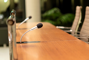 Image of a table with mics and chairs