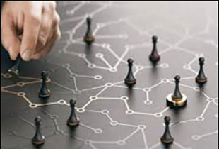 Hand moving a pawn piece on a board with a design similar to a circuit board