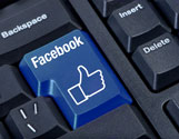 image of a navy-blue colored enter key on a computer keyboard with the word Facebook in white and below, a white outline of a the Facebook Like icon (a cuff with thumbs up hand)