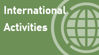 navigational icon consisting of the words International Activities in white text on a pea-green or Asparagus colored background and a 3/4 circle with a globe or world symbol which is a round shape with a grid symbolizing the planet earth; hyperlink to NRC Flickr International Activities photo album