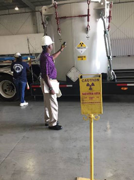 An NRC inspector verifies radiation levels from a radioactive material shipment being prepared for transport.