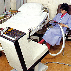 photo of a woman sitting in a chair receiving theraputic care, connected to a brachytherapy machine
