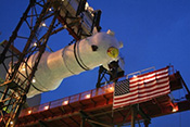 image at night of a steam tube generator above an American flag