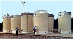 image of Storage and Transportation of Spent Nuclear Fuel with two workers inspecting of an array of spent fuel storage containers