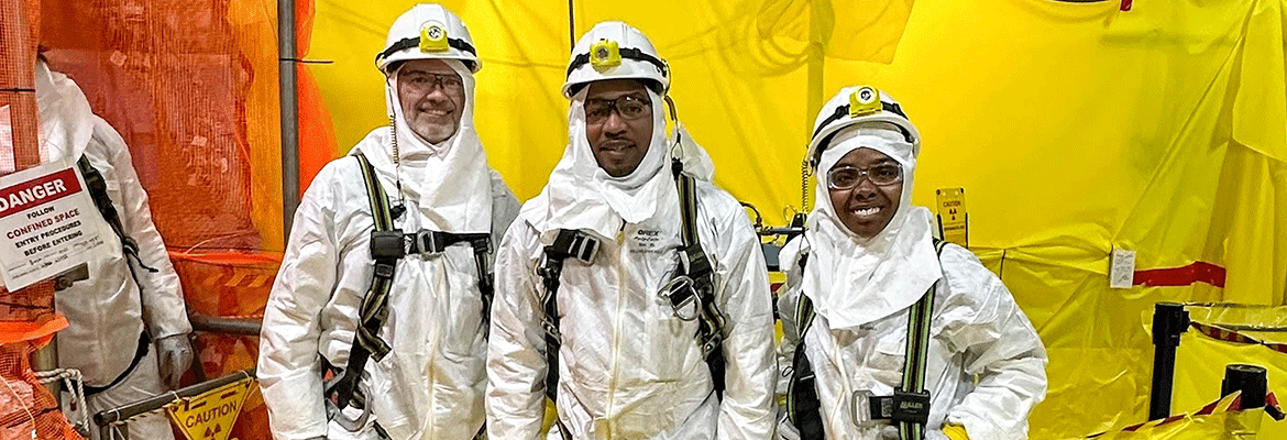 Three people in protective clothing