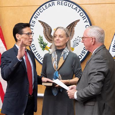 Commissioner Ho Nieh, left, is administered the oath of office by former Commissioner William Ostendorf, right, during a swearing-in ceremony at the U.S. Nuclear Regulatory Commission headquarters in Rockville, Md.