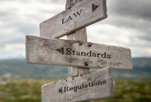 Direction post pointing the way to "Law", "Standards", and "Regulations"