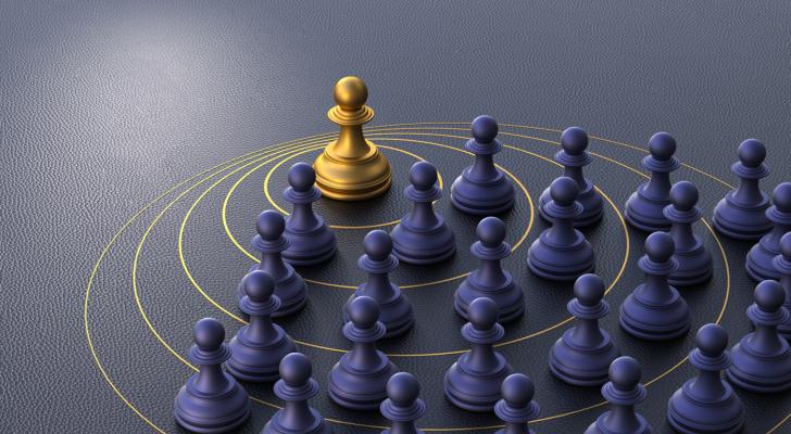 Purple chess pawns, one gold chess pawn
