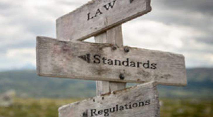 Direction post pointing the way to "Law", "Standards", and "Regulations"