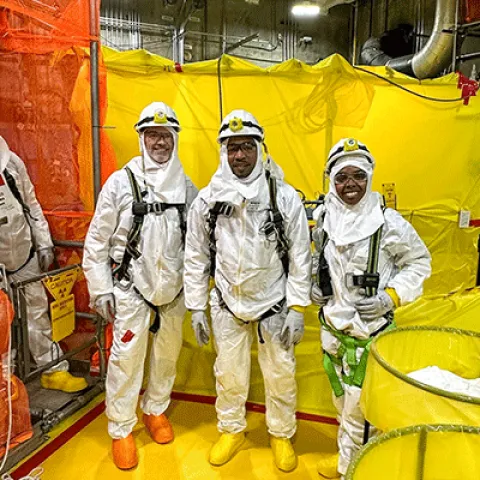 three people in protective clothing. 