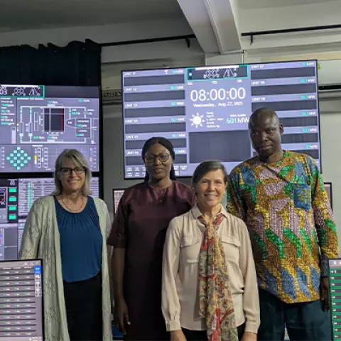 Image of four people standing in front of screens. 